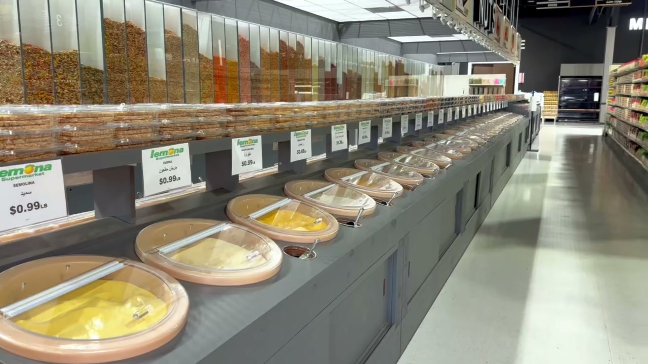 Bulk grains and international grocery aisle at Lemona with labeled bins.